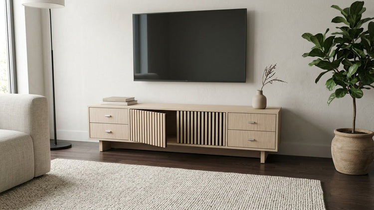 The Oslo Fluted TV Stand in light wood-look finish, with vertically fluted centre doors and four side drawers.
