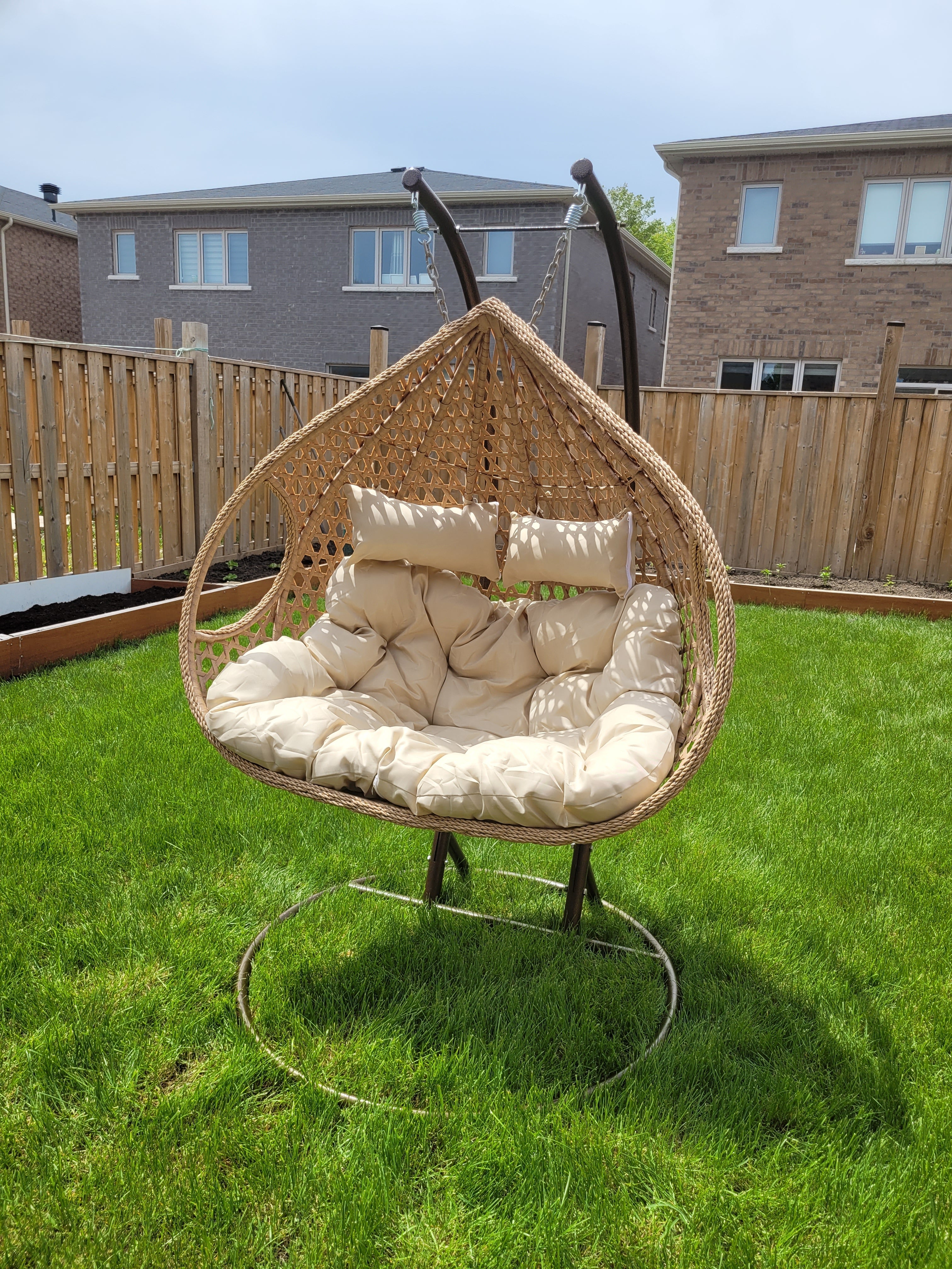 ARDYNAMIC AMARA double egg swing chair with light brown hand-woven PE rattan and beige outdoor cushions on durable iron stand