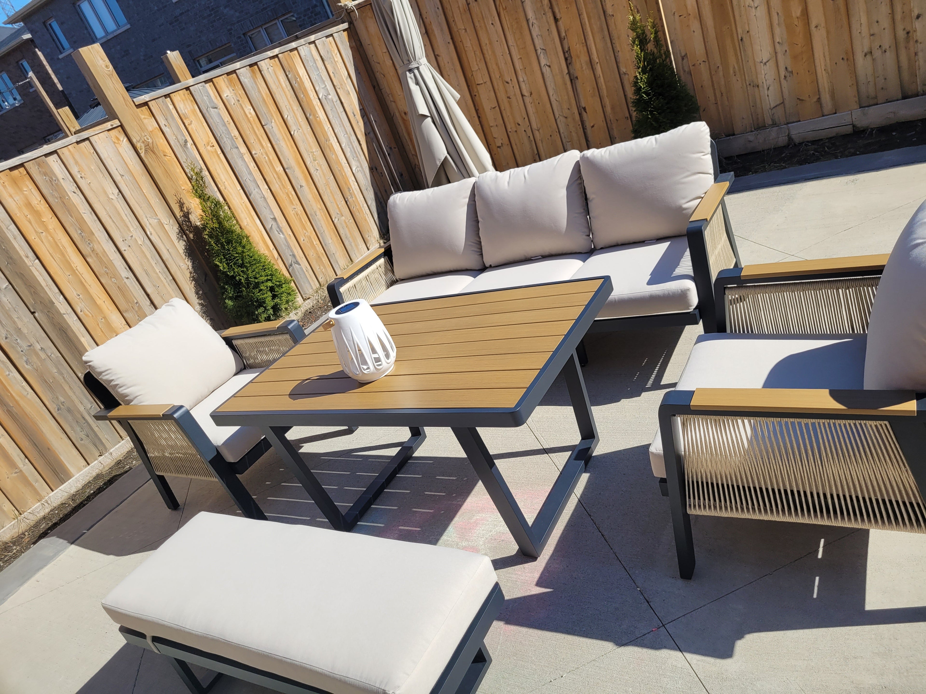 SNAKK SKITTENT Luxury Aluminum Dining Patio Set with teak wood accents and plush cushions in modern outdoor lounge setting