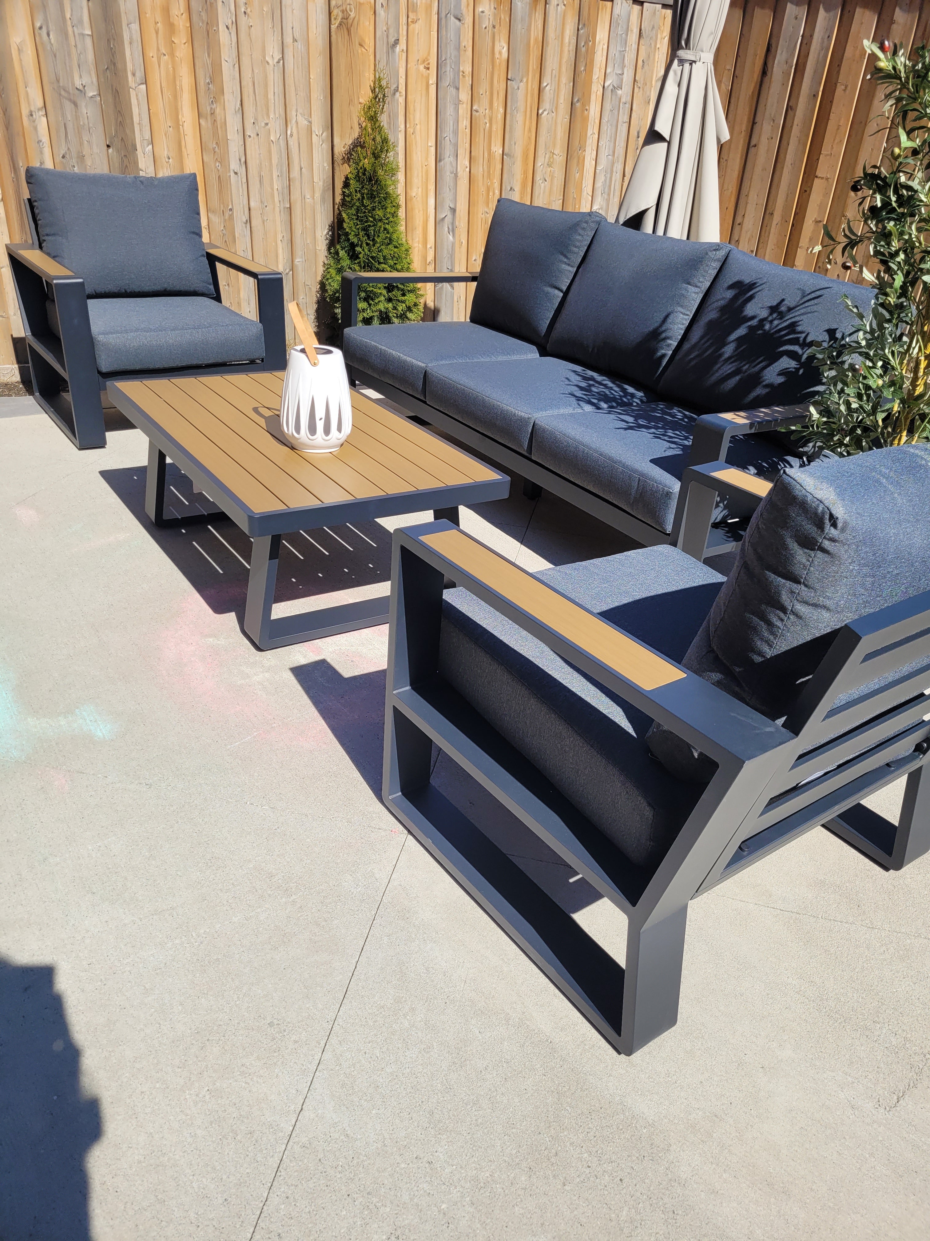5-seater aluminum patio set with polywood coffee table and weather-resistant cushions on a modern outdoor deck