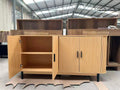 Reeded 4-door sideboard in natural oak with fluted front, matte black handles, and rounded corners.