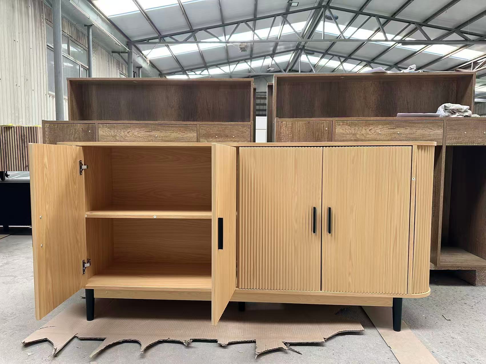 Reeded 4-door sideboard in natural oak with fluted front, matte black handles, and rounded corners.