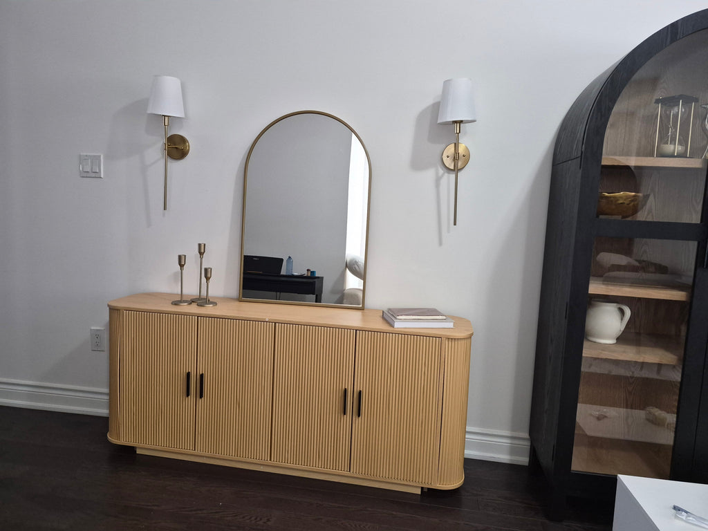 Reeded 4-door sideboard in natural oak with fluted front, black handles, and tapered legs in modern living room setting