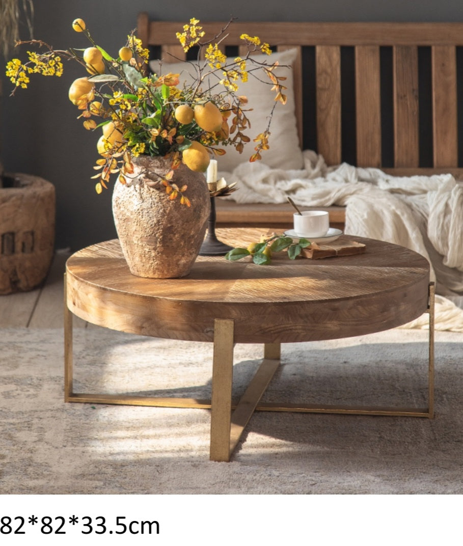 Ardynamic rustic coffee table with round wooden top and metal legs in cozy living room setting